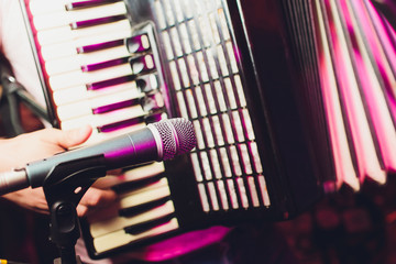 The musician plays the accordion close-up microphone.