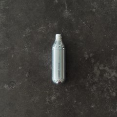 High angle shot of a nitrous oxide capsule on a concrete surface