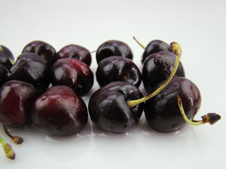 Fresh cherries with drops of water on a white background