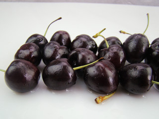 Fresh cherries with drops of water on a white background