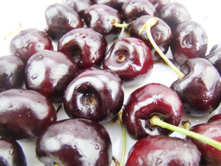 Freshly dripped cherries on a white background