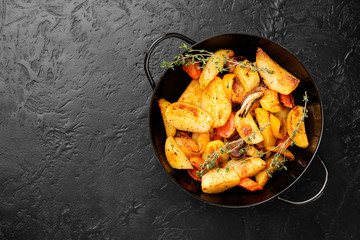 Roasted potato wedges with vegetables and herbs. 