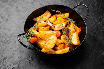 Roasted potato wedges with vegetables and herbs. 