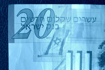 Twenty shekels banknote on a dark background close-up. Money background blue color toned