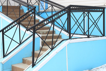 The staircase to the house is lined with ceramic tiles and iron railings painted black