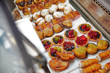pastry on display, pastries, buns, croissants, pies, cupcakes with berries