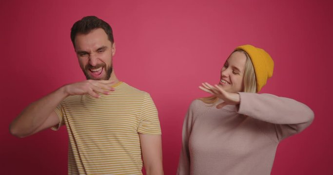 Male and female fist against each other at pink background slow motion