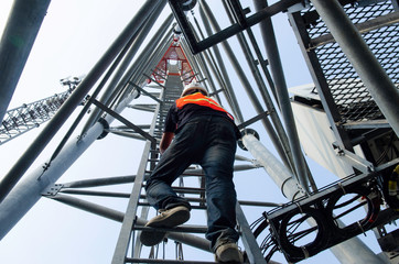 technician working on high telecommunication tower,worker wear Personal Protection Equipment for working high risk work,inspect and maintenance equipment on high tower.