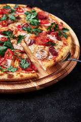 Supreme Pizza lifted slice with tuna and paprika isolated over black background