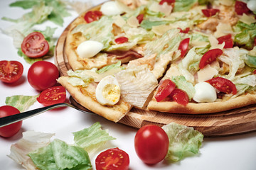 Pizza with tomatoes, salad, quail eggs and Parmesan isolated on white.