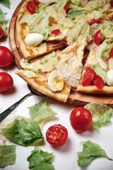 Pizza with tomatoes, salad, quail eggs and Parmesan isolated on white