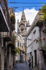 View from narrow street on a bell tower of Basilica of Santa Maria Assunta located in historic part of Randazzo city on Sicily Island in Italy