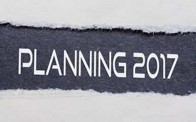 Planning 2017 words under torn black paper.