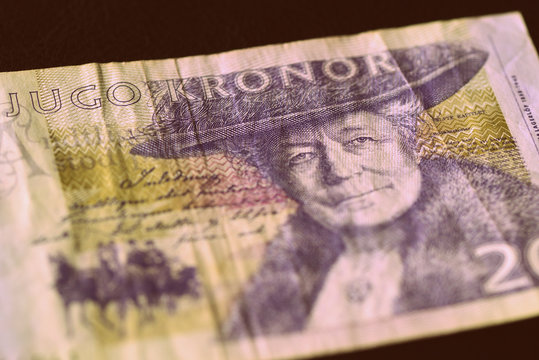 Outdated twenty Swedish crowns on a dark surface close-up. Money background retro style toned