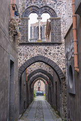 Fototapeta na wymiar Arch Street - Via Degli Archi in historic part of Randazzo city on Sicily Island in Italy, view with tower of Saint Nicholas Church