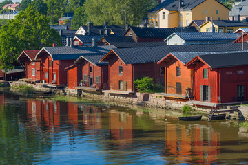 Obraz premium Old red barns on the Porvoonyoki River on a sunny July day. Old Porvoo, Finland