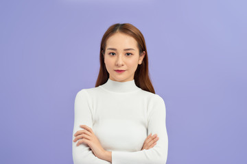 Obraz premium Young asian woman wearing turtleneck sweater standing over isolated white background happy face smiling with crossed arms looking at the camera. Positive person.