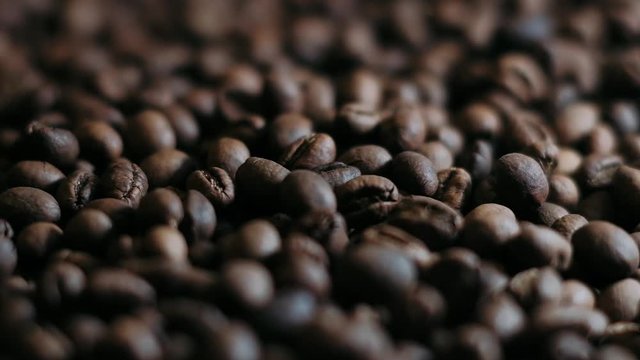 Dark Coffee Grains. Rotating and falling. Coffee beans. Close up of seeds of coffee. Beautiful seeds of coffee.