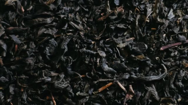 dry leaf tea falls on a heap with tea leaves.
