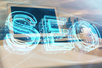 Multi exposure of table with computer and seo drawing hologram. Search optimization concept.