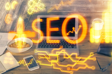 Multi exposure of table with computer and seo drawing hologram. Search optimization concept.