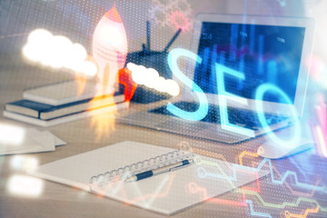 Multi exposure of table with computer and seo drawing hologram. Search optimization concept.