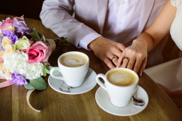 Fototapeta na wymiar Wedding couple drink coffee and holding hands. Wedding card
