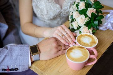 Wedding couple drink coffee and holding hands. Wedding card