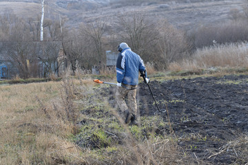 Digger with metal detector in the field