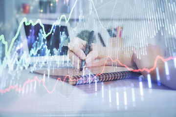 Financial graph displayed on woman's hand taking notes background. Concept of research. Double exposure