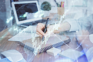 Financial charts displayed on woman's hand taking notes background. Concept of research. Double exposure