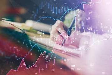 Financial forex graph displayed on hands taking notes background. Concept of research. Multi exposure