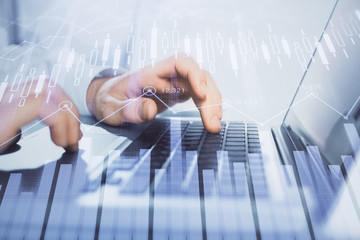 Double exposure of market chart with man working on computer on background. Concept of financial analysis.