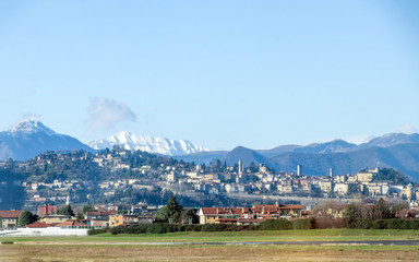 Panoramic view on Bergamo old town in winter sunny day with blue sky from Orio al Serio International Airport