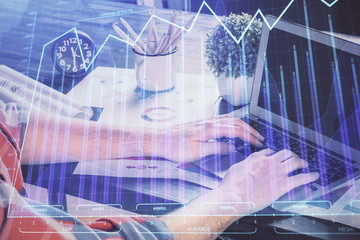 Fototapeta na wymiar Double exposure of stock graph with businessman typing on computer in office on background. Concept of hard work.