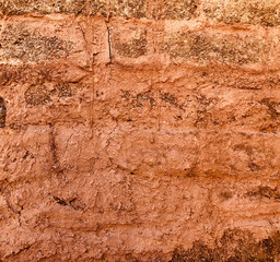red clay weathered wall of rural vintage country house closeup as clay background barn in the countryside