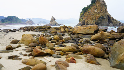 rocky ocean shore in japan. Unusually shaped volcanic rocks in the clear turquoise blue water of...