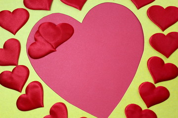 Abstract background in the form of many hearts of red color and one big