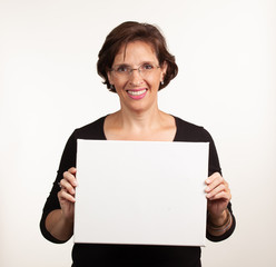 Fototapeta premium Woman holding up a blank white sign with room for your copy