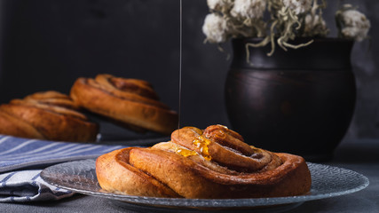Freshly baked cinnamon bun with honey