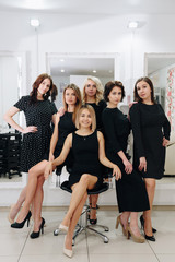 Fototapeta premium six beautiful girls in black dresses in a beauty salon