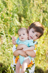 Little BRO. Cute child with his little baby brother playing on nature outdoors.