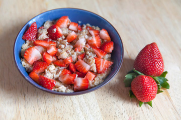 Bowl of oatmeal with fresh strawberries for breakfast
