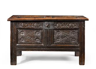 Old small coffer chest trunk early made from oak with detail carving and metal lock isolated on white