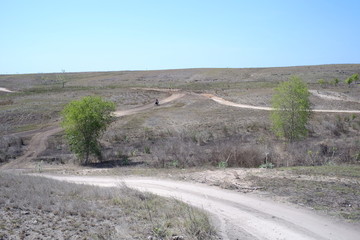 A dusty dirt road that cuts through dry field land in Southwest Sumba, East Nusa Tenggara, Indonesia.