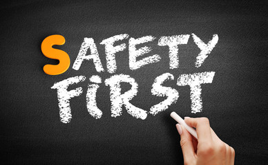 Safety First text on blackboard, concept background