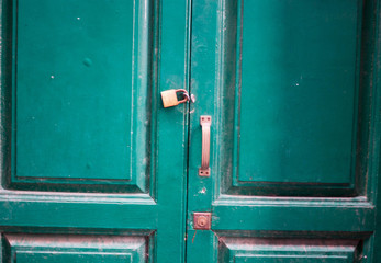 Green old dirty door with a lock and key hole