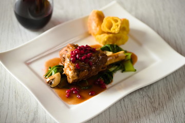 Lammstelzen mit gnocchi parisienne und Granatapfelkernen auf Pak Choi und Champignons