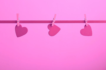 Valentine day greeting card with copy space and hearts pinned to rope on pink