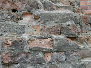Destroyed wall of red brick and cement, interesting texture closeup